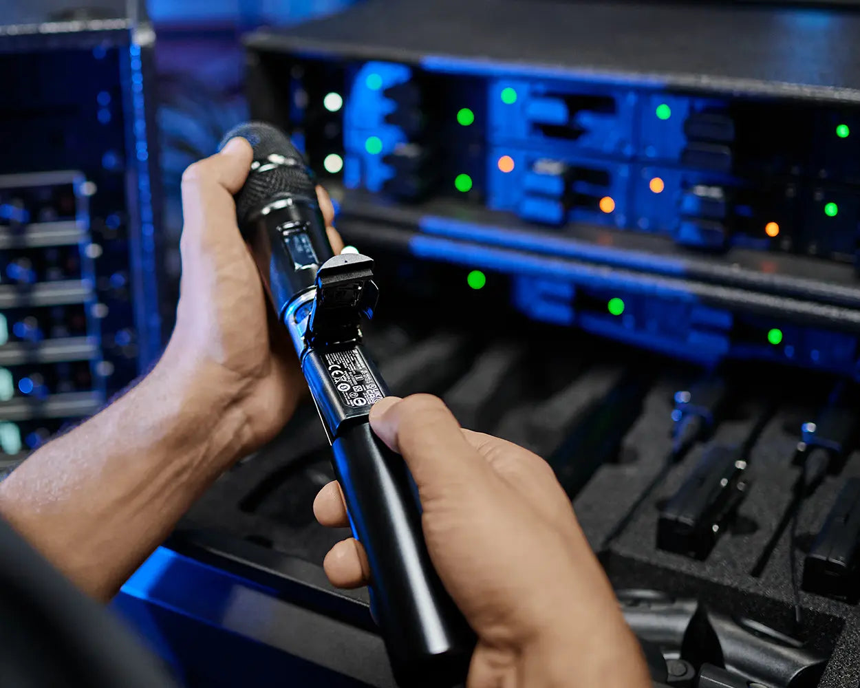 Audio engineer swapping BA70 battery in Sennheiser EW-DX SKM handheld transmitter